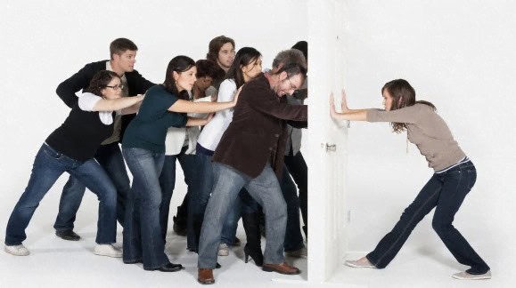 Employees using overt resistance to push against door being held by team lead